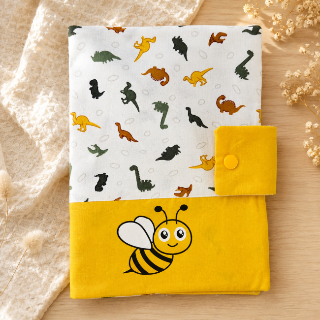 Détail de l’abeille sur le protège-carnet de santé artisanal jaune