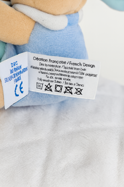 Étiquette d’entretien d’un doudou bleu en polyester, adapté dès la naissance