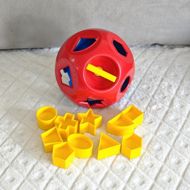 Sphère Tupperware rouge et bleue avec pièces de tri jaunes