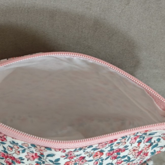 Trousse artisanale fleurie ouverte montrant sa doublure claire et son intérieur vide