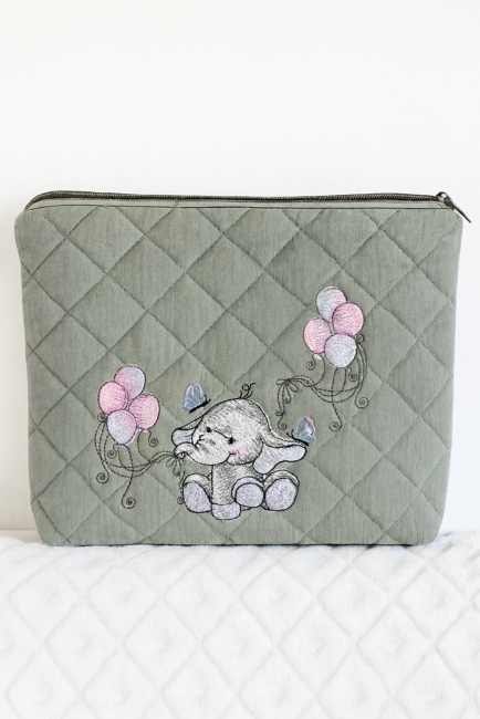 Trousse bébé verte matelassée avec broderie éléphant et ballons pastel, posée sur fond blanc texturé