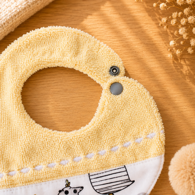 Fermeture pression du bavoir artisanal bébé Gros plan du bouton pression du bavoir artisanal bébé en fibre de bambou