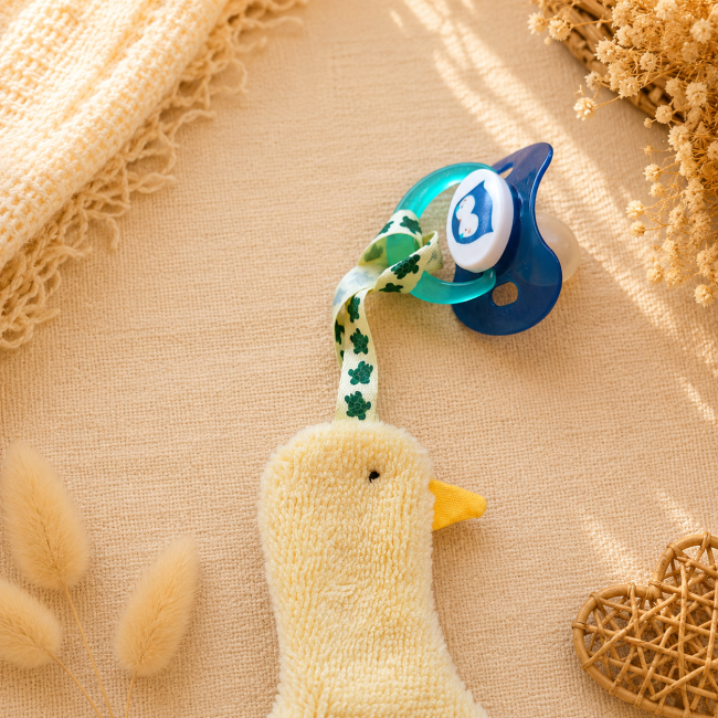 Attache-sucette bébé – Ruban blanc à motifs verts Attache-sucette bébé en fibre de bambou avec ruban blanc à motifs verts et sucette bleue