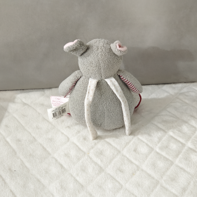 Boîte à musique lapin Doudou et Compagnie vue de dos, tissu gris et rose, bon état.