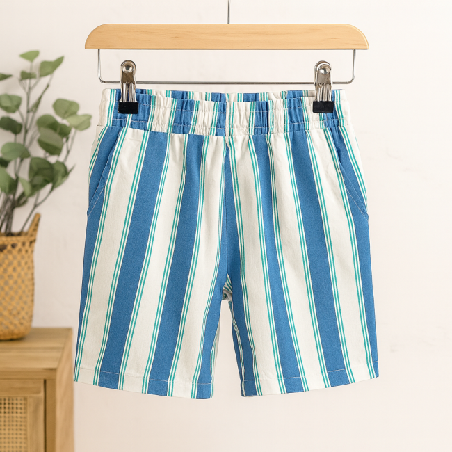 Short enfant 6 ans rayé – décor naturel. Short rayé bleu blanc vert pour enfant, taille 6 ans, suspendu avec décor eucalyptus.