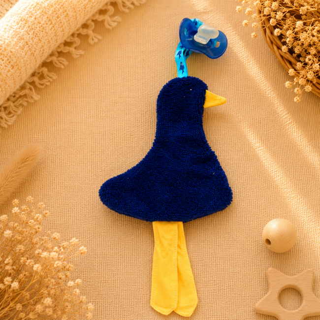 Attache-sucette artisanal canard bleu marine avec longues pattes jaunes et ruban bleu