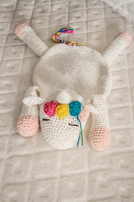 Jouet licorne en crochet avec pompons colorés, sabot rose et queue tressée multicolore