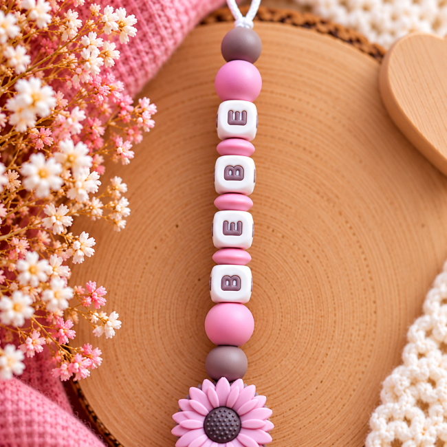 Gros plan des perles en silicone vieux rose et marron chocolat de l’attache-sucette bébé