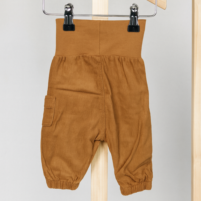 Pantalon bébé H&M en velours côtelé brun suspendu sur cintre, taille élastique et poche latérale