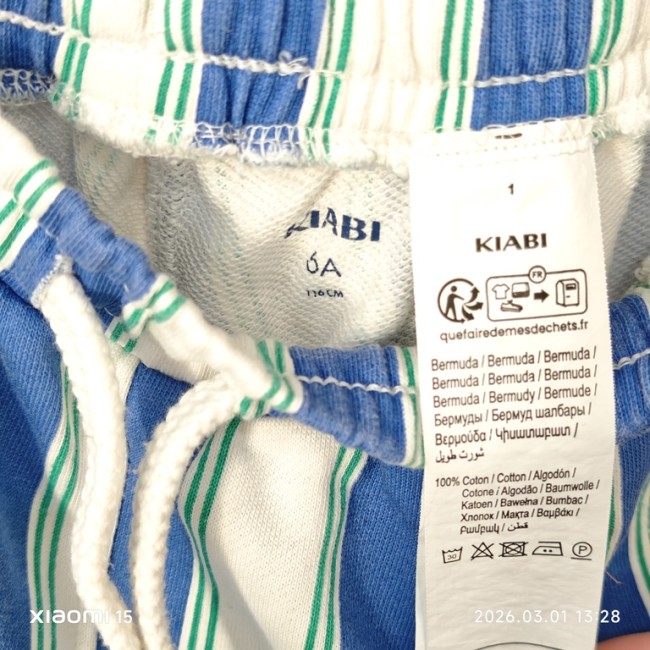 Étiquette du short KIABI 6 ans – 100% coton. Étiquette intérieure du short KIABI 6 ans indiquant 100% coton et consignes d’entretien.