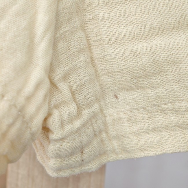 Détail du tissu gaufré en coton léger - vêtement enfant confortable Gros plan sur tissu gauffré jaune pâle, coton léger et respirant pour vêtement enfant