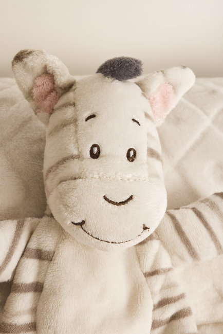 Zèbre en peluche beige et gris avec visage brodé et oreilles roses