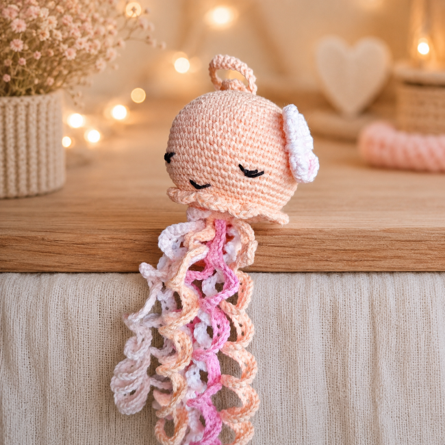 Jouet artisanal en crochet représentant une pieuvre aux tentacules pastel sur fond doux beige