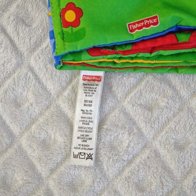 Étiquette Fisher-Price – instructions de lavage Étiquette d’entretien Fisher-Price originale sur livre tissu