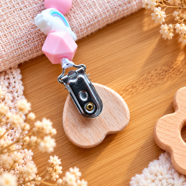 Dos de l’attache sucette avec pince métallique argentée fixée sur un cœur en bois naturel et perles silicone pastel