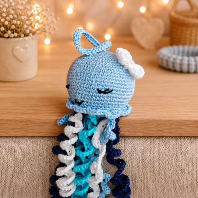 Pieuvre amigurumi bleue au crochet posée sur un plaid beige avec lumière cocooning