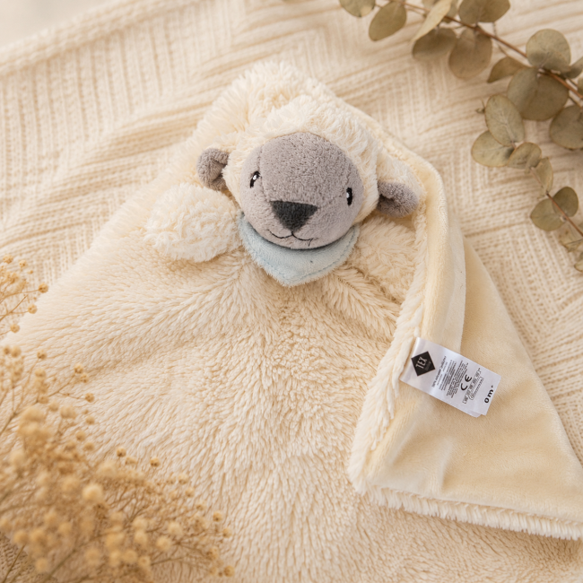Doudou mouton plat écru et gris dans une ambiance douce pour chambre de bébé