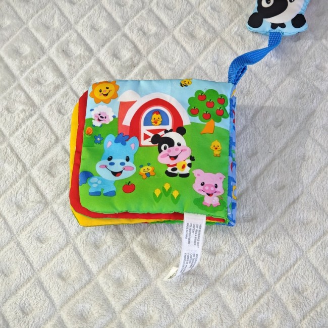 Livre tissu Fisher-Price – jouet vache attachée Livre tissu Fisher-Price ferme avec vache à grelot, vue rapprochée