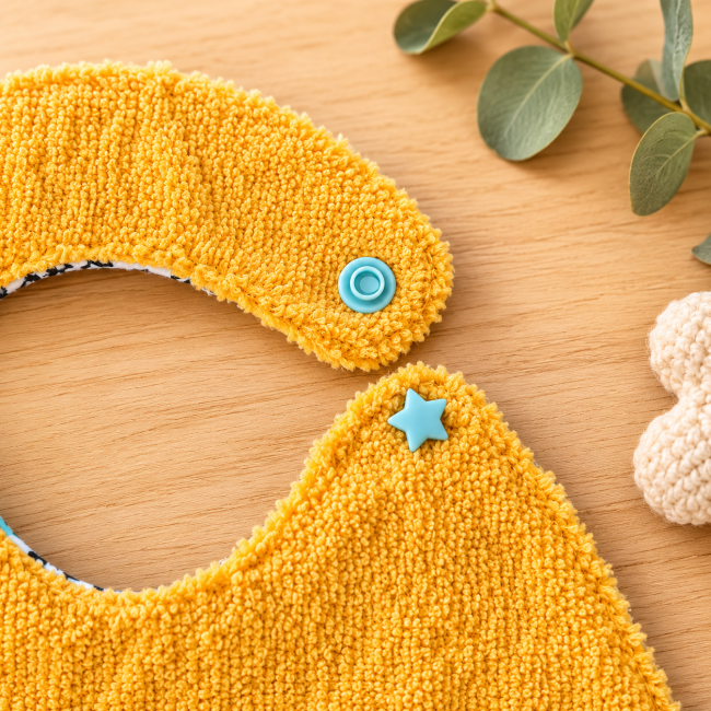 Gros plan du bouton pression étoile d'un bavoir artisanal bébé en fibre de bambou