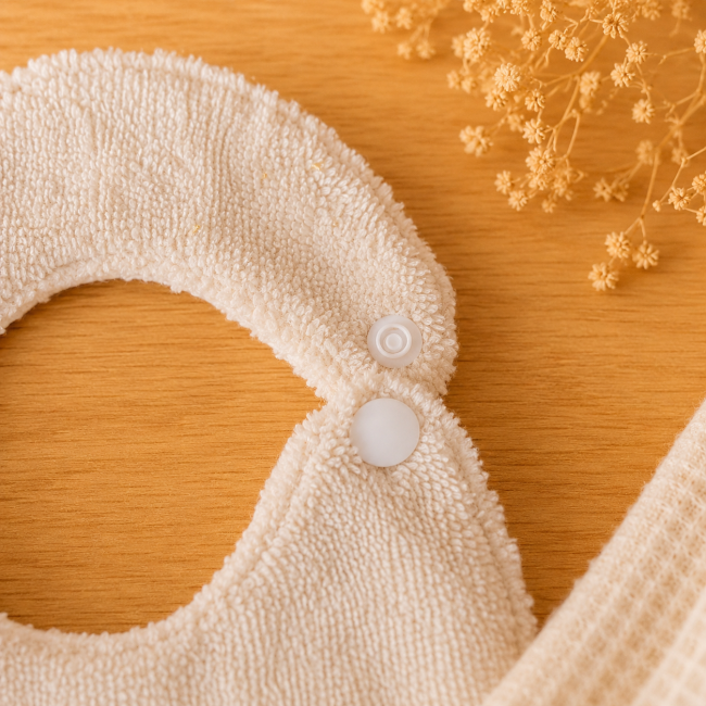 Détail de la fermeture par bouton pression d'un bavoir bébé en fibre de bambou