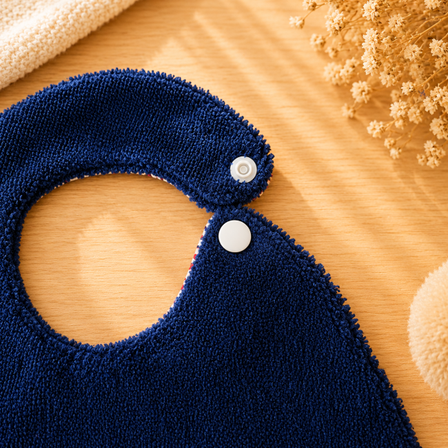 Gros plan bouton pression du bavoir artisanal bébé bleu marine