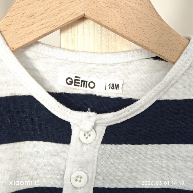 T-shirt GÉMO 19 mois rayé bleu et blanc, col rond et patte boutonnée, suspendu sur cintre.