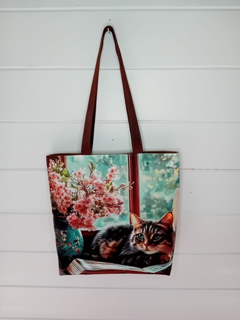 Sac cabas chat installé sur un livre dans un décor fleuri, création artisanale – Animaux et passions