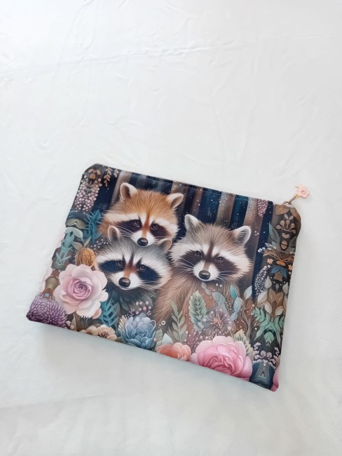 Trousse Ratons laveurs et fleurs – Les bonnes affaires | Les Cabas en folie Trousse Ratons laveurs et fleurs en polyester imperméable avec fermeture zippée et breloque – Les Cabas en folie