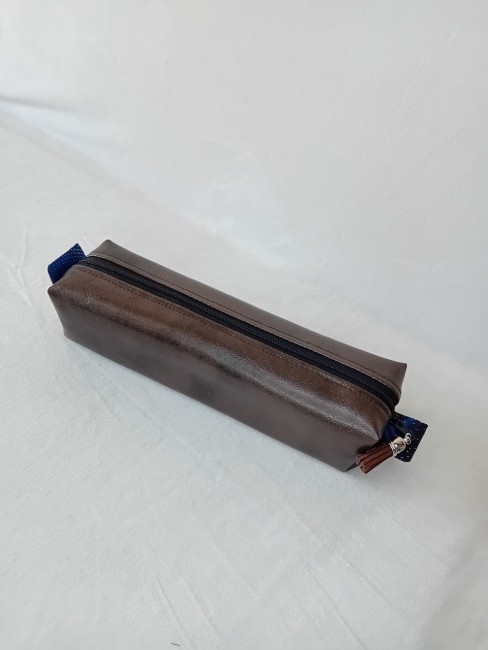 Trousse artisanale en simili cuir avec fermeture zippée et pompon en suédine