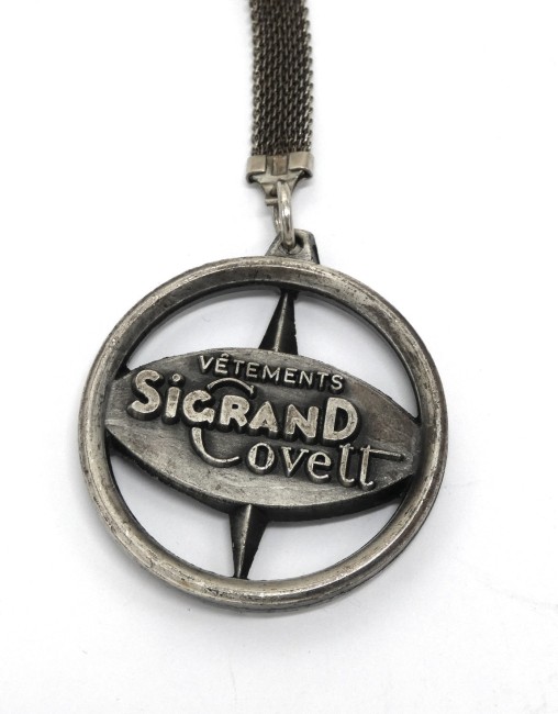 Ancien porte clé publicitaire en  métal rose des vents vêtements Sigrand