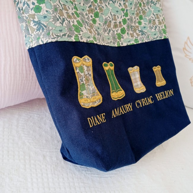 Quatre bottes de pluie brodées avec un prénom sous chaque motif sur un sac cabas personnalisé