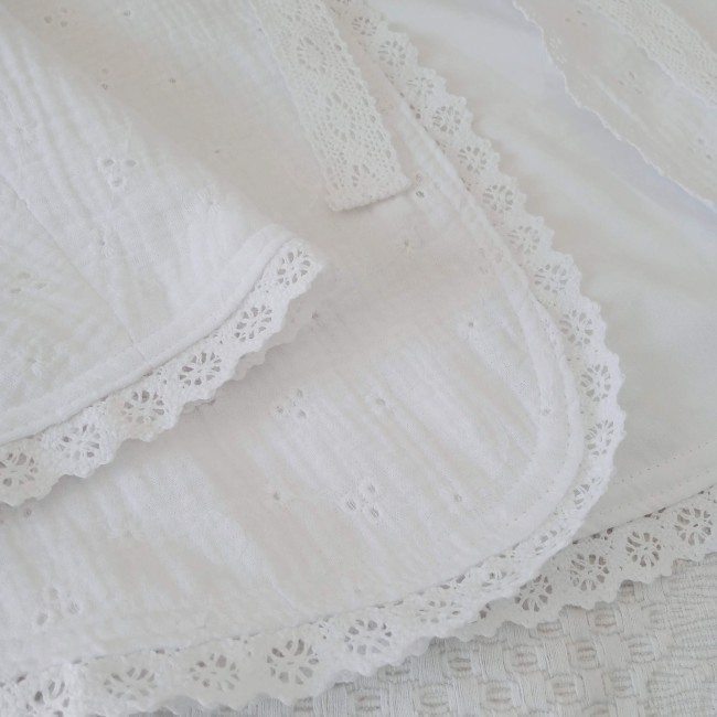 Vue rapprochée des finitions en dentelle de la cape