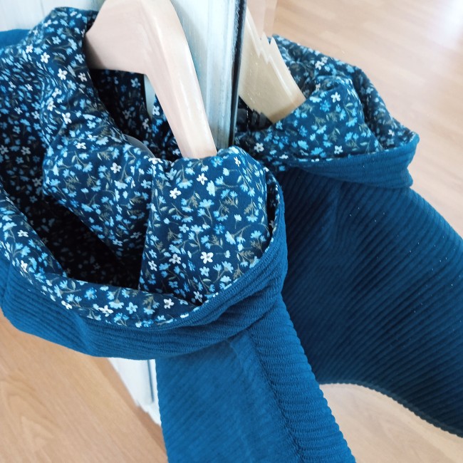 une jolie cape en velours côtelé de couleur paon doublée d'un superbe tissu fleuri