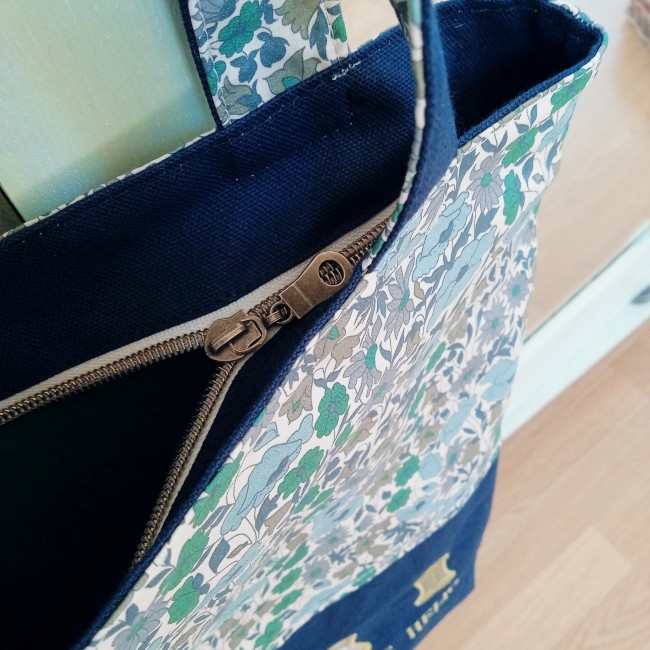 Gros plan sur la fermeture zippée métallique et les finitions du totebag cabas doublé