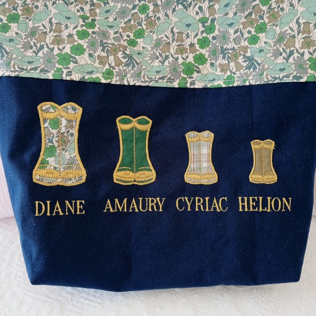Détail de la broderie de bottes de pluie colorées et des prénoms sur un totebag bleu marine