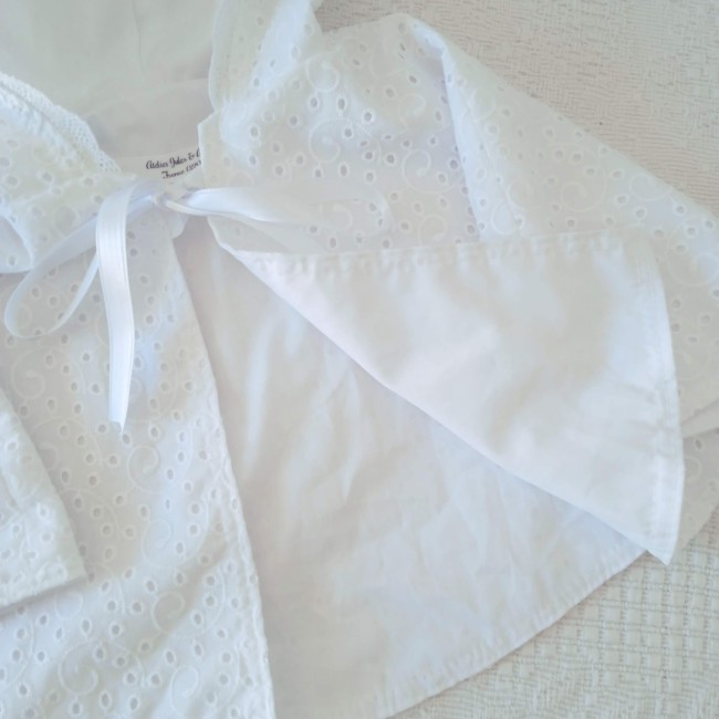Cape de baptême blanche en broderie anglaise ajourée avec capuche festonnée et ruban de satin