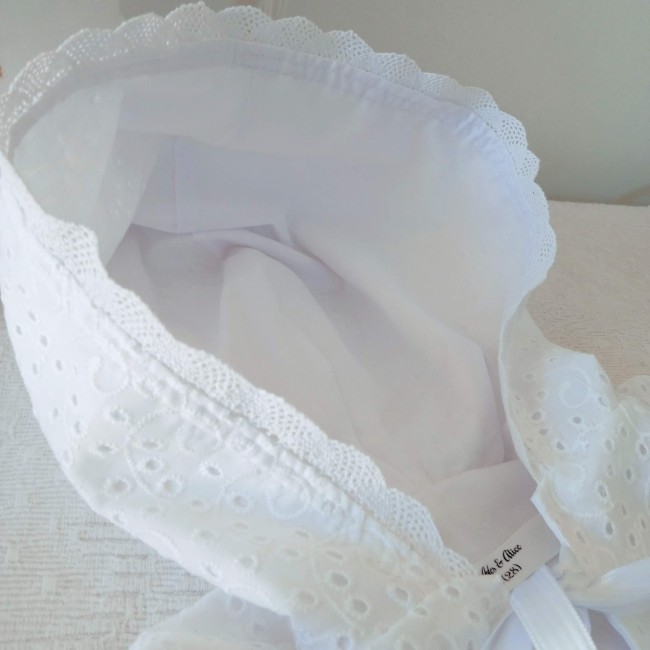 Cape de baptême blanche en broderie anglaise ajourée avec capuche festonnée et ruban de satin