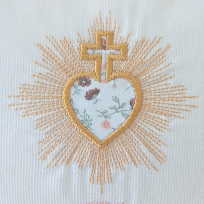 Détail du Sacré-Cœur brodé avec appliqué de tissu Gros plan sur le Sacré-Cœur brodé avec appliqué de tissu fleuri sur le coussin de mariage personnalisé