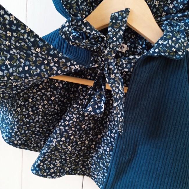 une jolie cape en velours côtelé de couleur paon doublée d'un superbe tissu fleuri