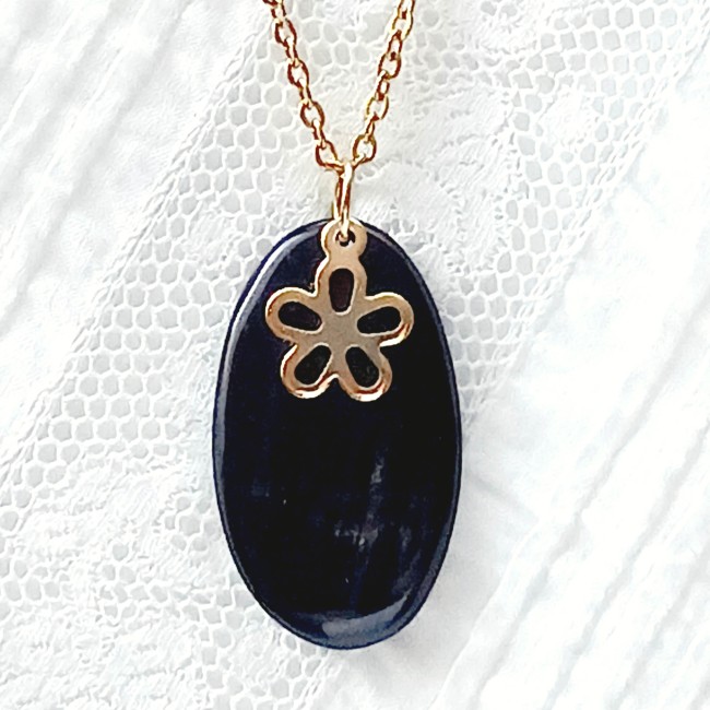 Pendentif en corne noire avec breloque fleur en acier doré