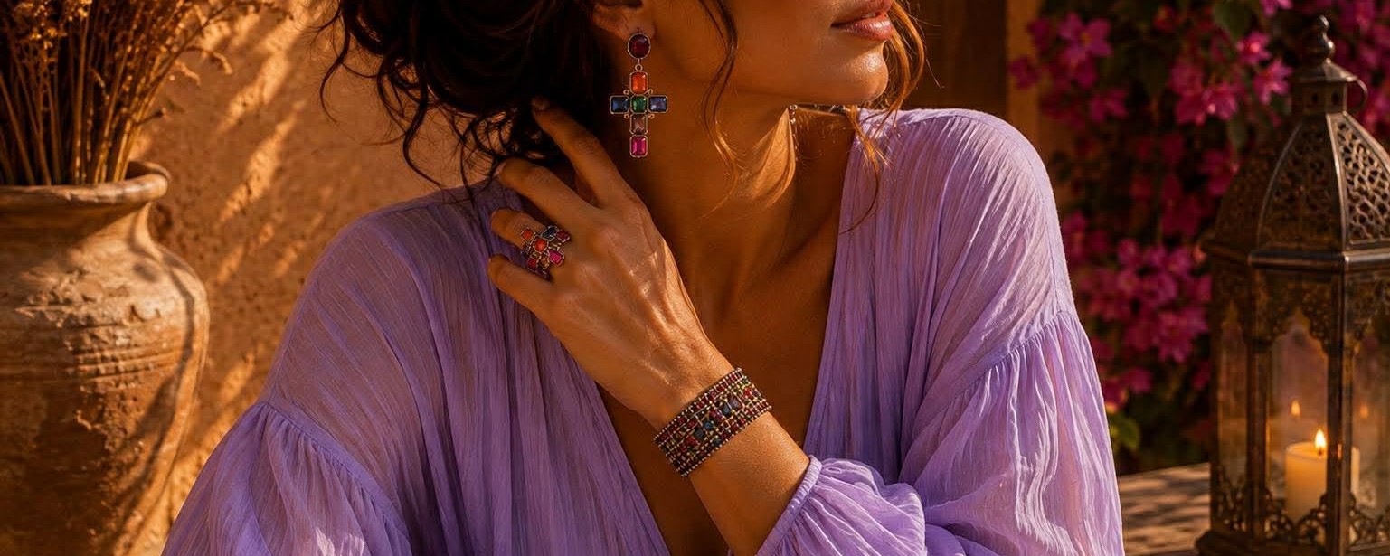 Femme bohème chic portant un assortiment de bijoux colorés Caprissa avec collier, boucles d’oreilles et bracelet en acier inoxydable, tons rose fuchsia, jaune et marron.