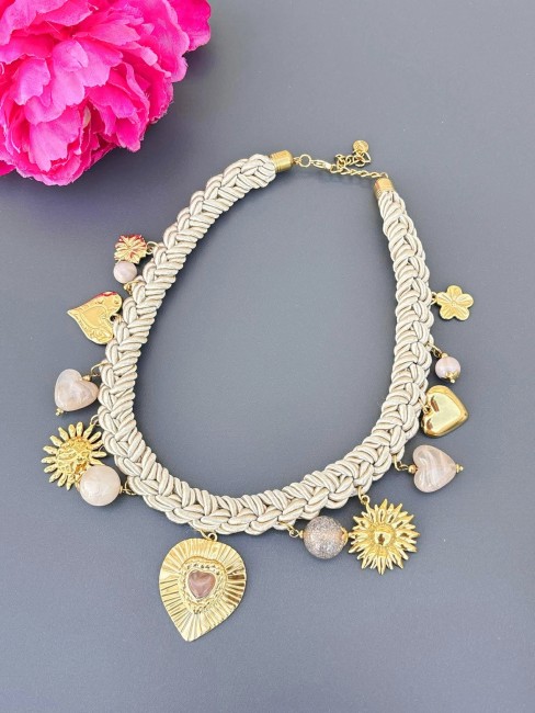 Collier chic au style italien formé par un cordon tressé miel beige et réhaussé par des pampilles en acier inoxydable doré en forme de coeur de soleil et de fleur avec des perles de résine
