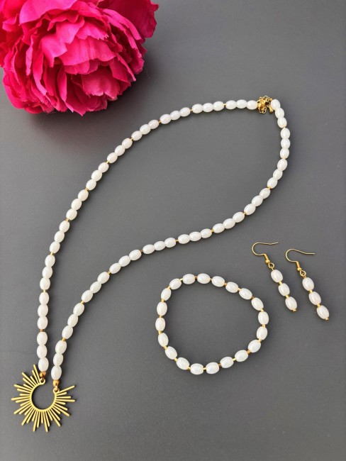 Ensemble composé d'un collier, de boucles d'oreilles et d'un bracelet de perles naturelles de couleurs blanches pour un style hypnotisant coloré et bohème chic; à noter que le collier est réhaussé d'un pendentif en acier inoxydable en forme de soleil