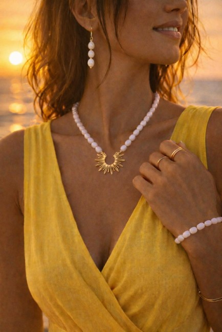 Ensemble composé d'un collier, de boucles d'oreilles et d'un bracelet de perles naturelles de couleurs blanches pour un style hypnotisant coloré et bohème chic; à noter que le collier est réhaussé d'un pendentif en acier inoxydable en forme de soleil