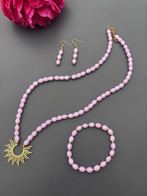 Ensemble composé d'un collier, de boucles d'oreilles et d'un bracelet de perles naturelles de couleurs parmes pour un style hypnotisant coloré et bohème chic; à noter que le collier est réhaussé d'un pendentif en acier inoxydable en forme de soleil