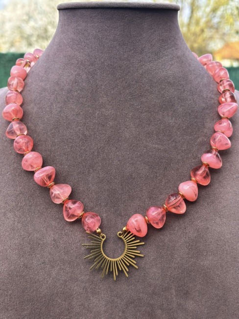 Collier fantaisie composé de perles naturelle de couleurs corail et réhaussé par un pendentif solaire en acier inoxydable pour un effet bohème chic et raffiné 