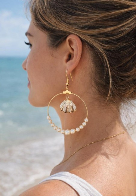 Boucle d'oreille fantaisie composé de perles d'eau douce blanches montées sur la créole et d'un coquillage au centre