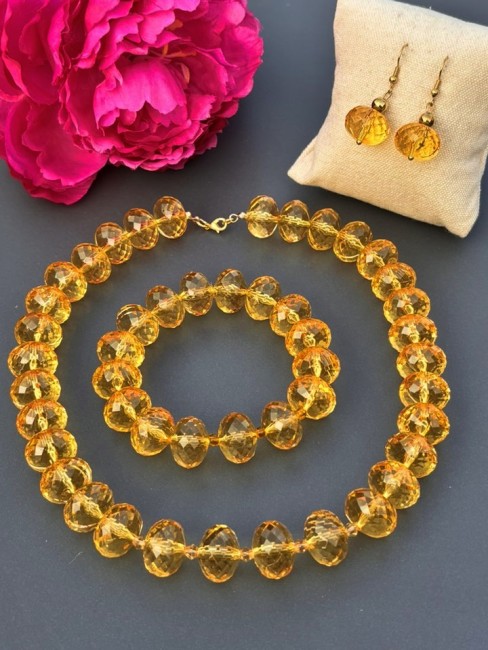 Parure 3 pièces fantaisie composée d'un collier d'un bracelet et de boucles d'oreilles aux grosses perles de verre jaune cristal pour un look bohème chic et solaire