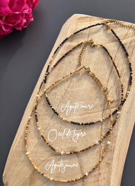 Collier hyper chic et féminin où des perles naturelles d'agate jaune, d'agate noire et d'oeil de tigre se marient parfaitement  des perles d'eau douce et des perles dorés en acier inoxydable pour un rendu bohème chic