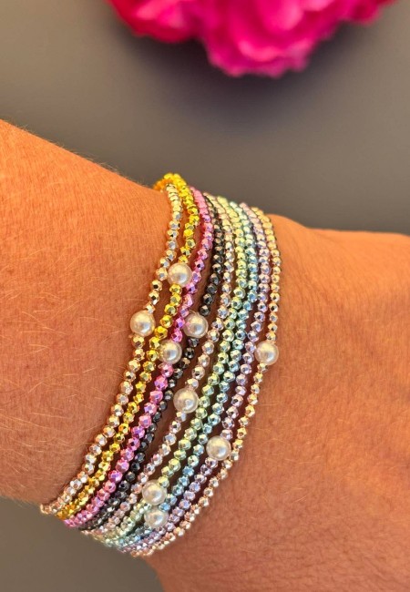 Bracelet fantaisie composé de perles métalliques facettées aux couleurs lumineuses et d'une perle d'eau douce naturelle  pour un look bohème chic et solaire